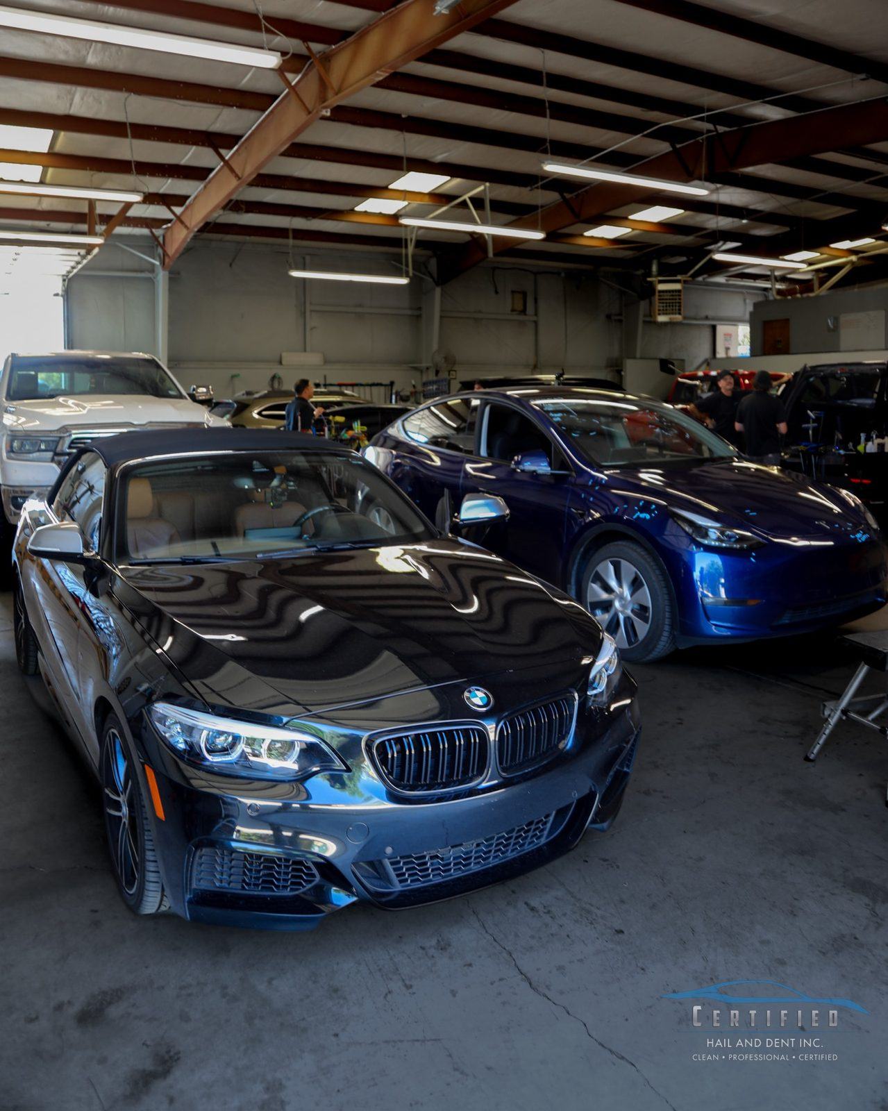 Interior of Certified Hail and Dent Colorado Springs shop with vehicles receiving hail damage repair